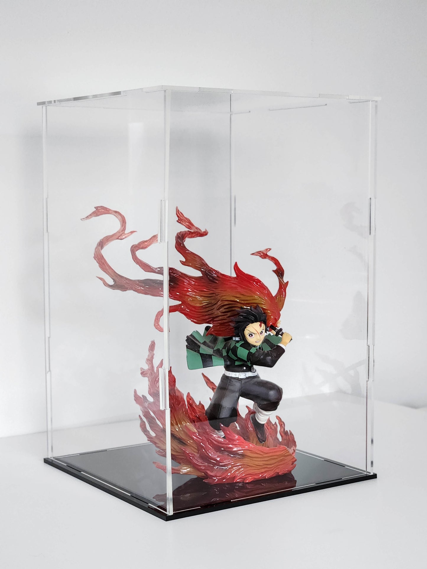 Figurine with red hair and flames in a clear display case on a white background