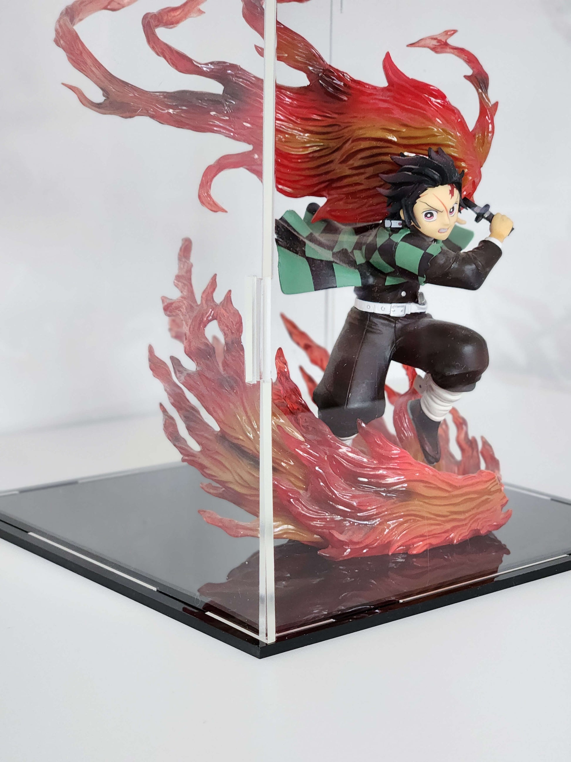 Action figure with red and black hair in a dynamic pose, enclosed in a clear display case.