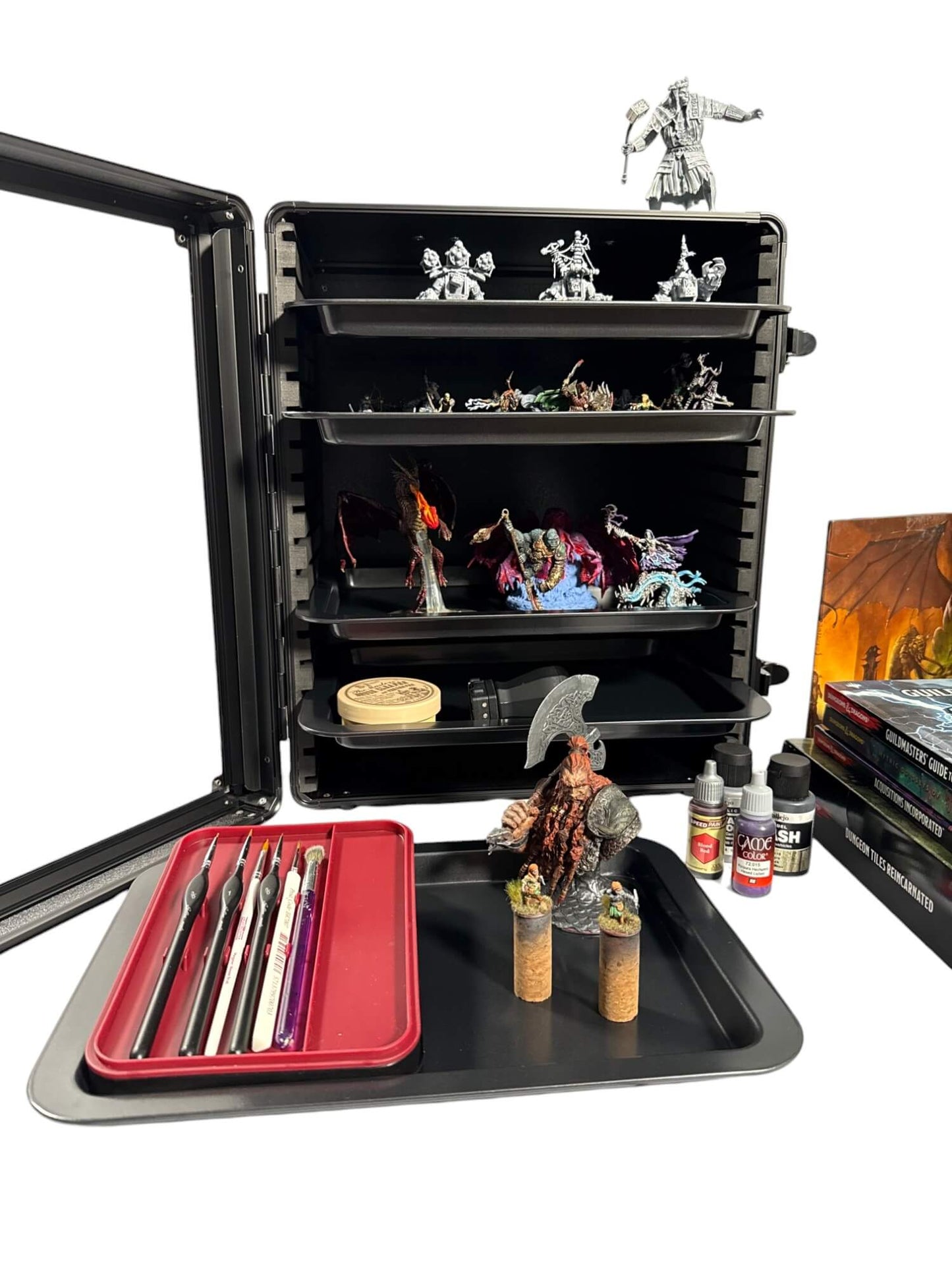 Black organizer with miniatures, tools, and paint bottles on a white background