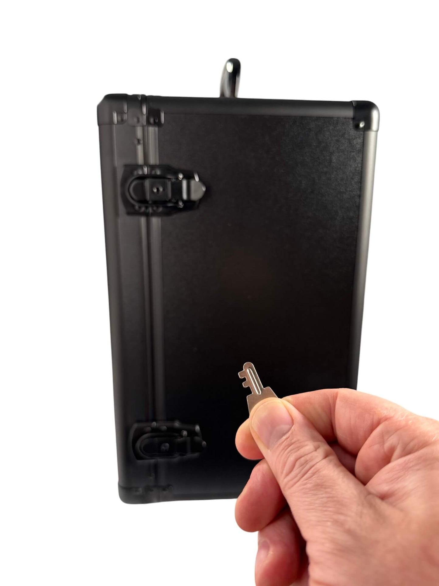 Black case with a small key on a white background