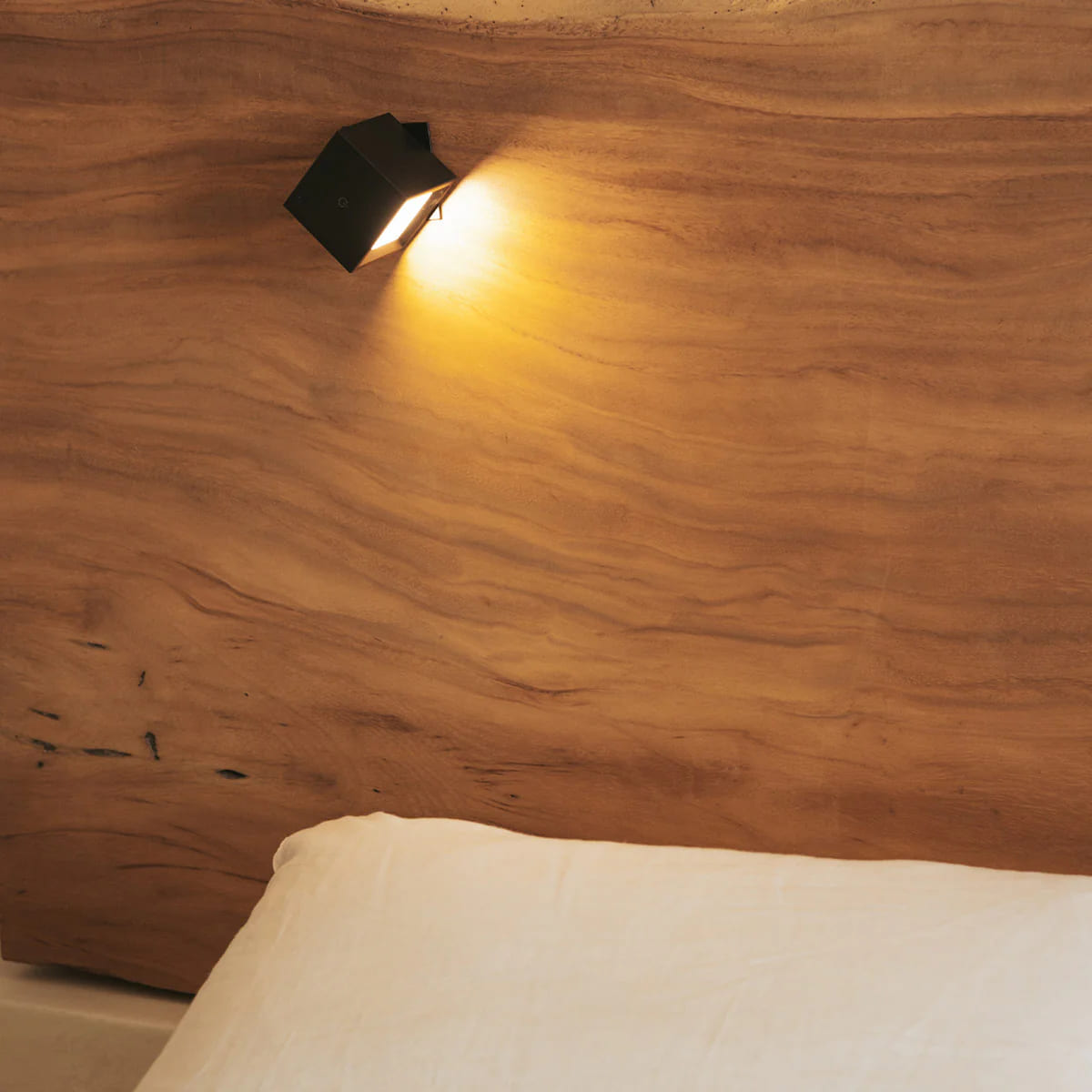 Black wall-mounted light fixture on a wooden wall
