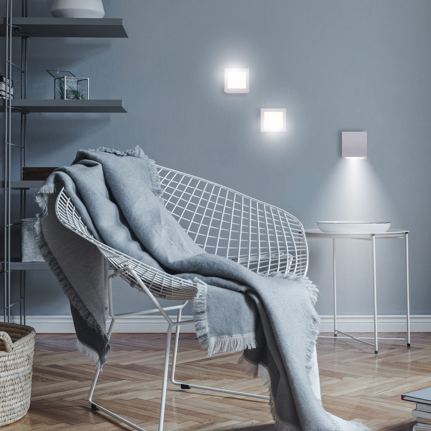 Modern interior with a wire chair draped with a blanket, shelves, and wall lights.