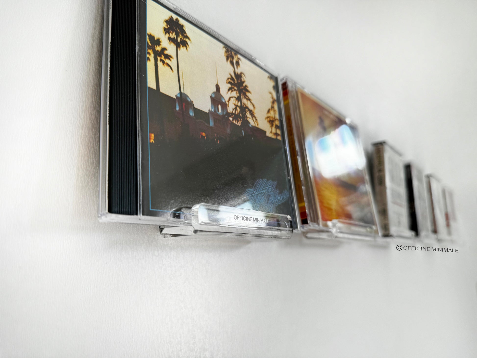 CD cases with artistic covers on a white surface
